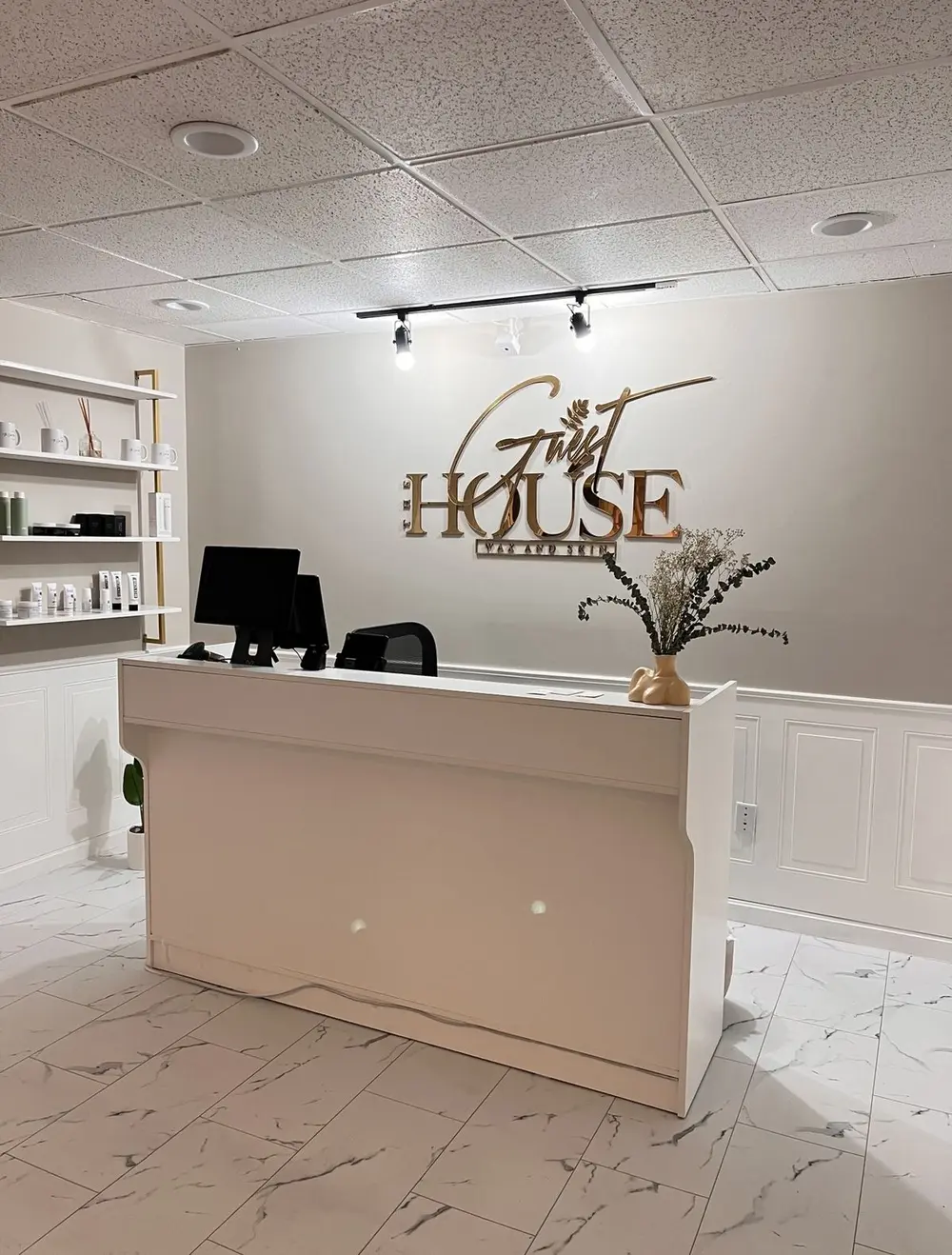Front desk and gold Guest House sign inside the wax and skin studio in Rocky Hill, CT